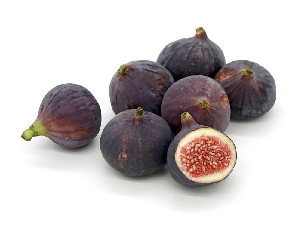 A close-up of dried figs arranged on a rustic wooden table, showcasing their rich texture and natural sweetness, symbolizing their health benefits and contribution to overall wellness.